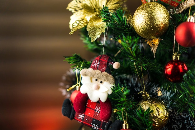 Arbre de Noël assemblé avec des ornements. Boules rouges, argentées et dorées, coffrets cadeaux, lumières, Père Noël et autres. Mise au point sélective.
