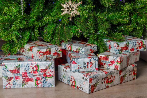 L'arbre de Noël a beaucoup de boîtes de cadeaux enveloppées sous lui