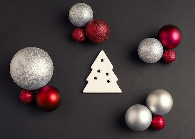 Arbre de Noël blanc et boules de Noël d'une couleur différente sur fond sombre