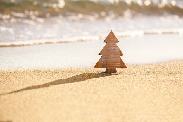 Arbre de Noël en bois de bois sur un sable sur la plage tropicale près de l'océan