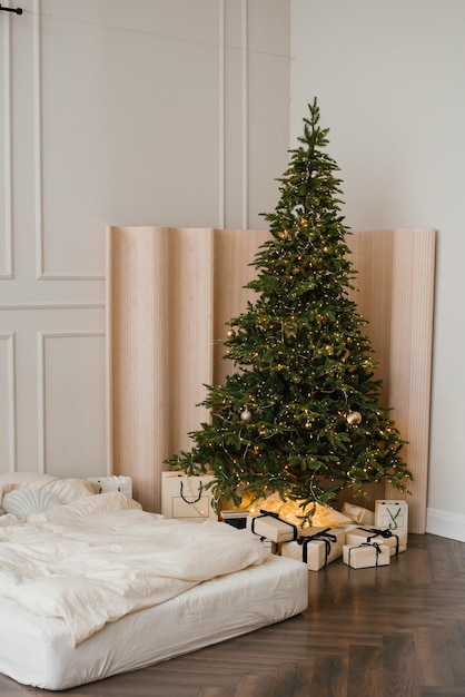 Arbre de Noël avec des cadeaux à l'intérieur d'une chambre élégante