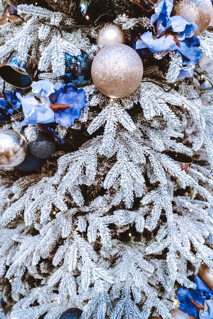 Arbre de Noël couvert de neige avec des fleurs argentées et bleues Boules de Noël Bonne année