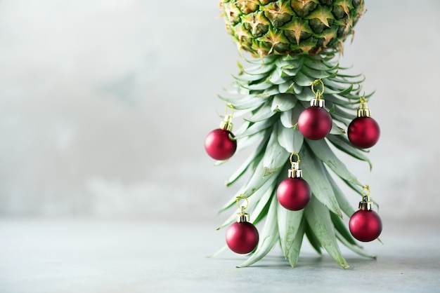 Arbre de Noël créatif en boule d&#39;ananas et rouge sur fond de béton gris