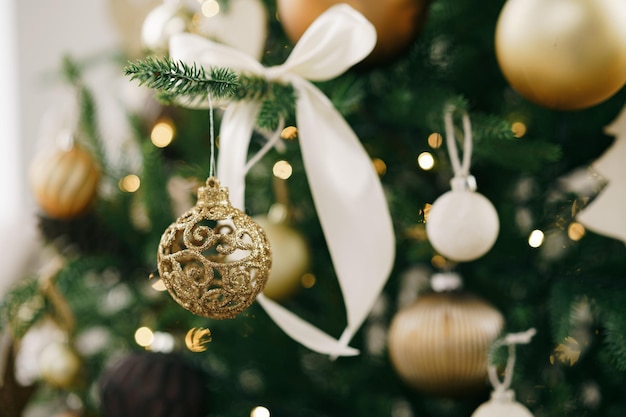 Photo arbre de noël décoré de boules blanches et dorées se bouchent