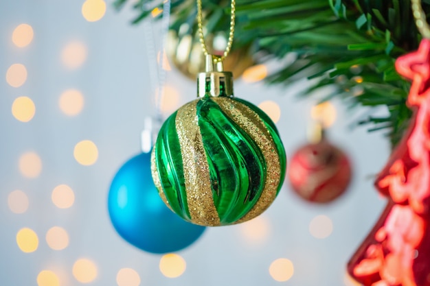 Arbre de Noël décoré de boules sur fond de branches de pin