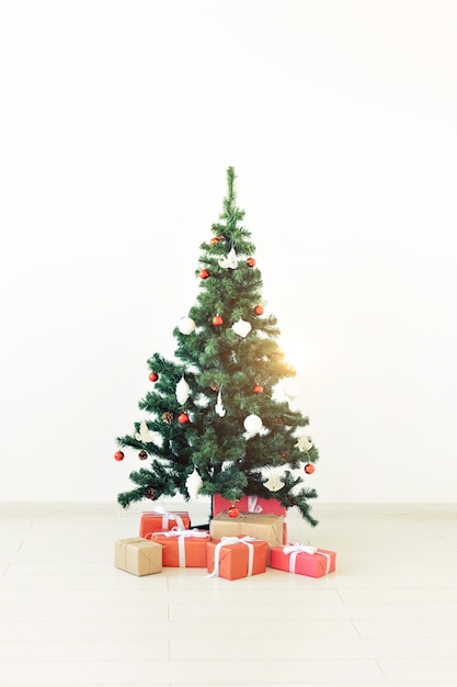 Arbre de Noël décoré et cadeaux sur fond blanc.