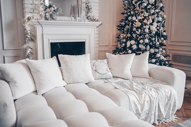 Arbre de Noël décoré avec des cadeaux à l'intérieur du salon classique blanc