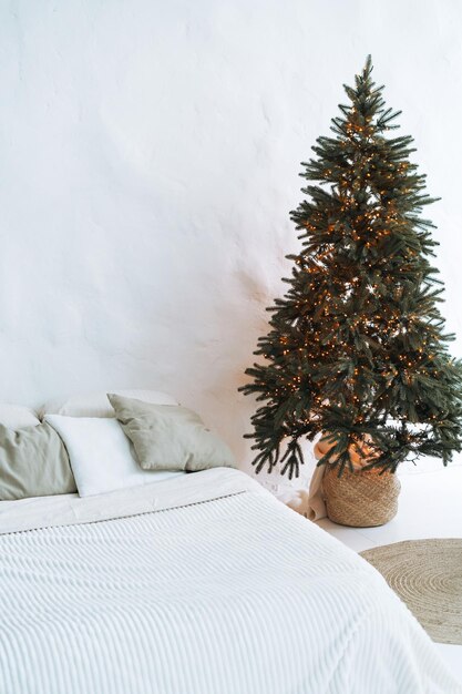 Arbre de Noël décoré dans la chambre à coucher dans un intérieur éco-lumineux à la maison