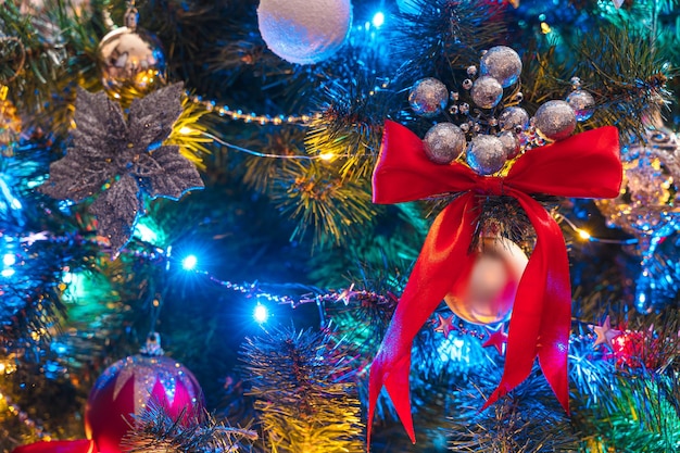 Arbre de Noël décoré de gros plan de guirlandes colorées, de jouets et de ballons. Vue latérale, verticale. Mise au point sélective.