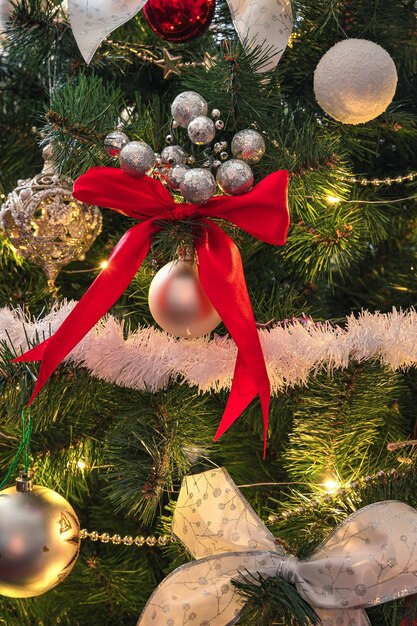 Arbre de Noël décoré de gros plan de guirlandes, de jouets et de ballons. Vue latérale, verticale.