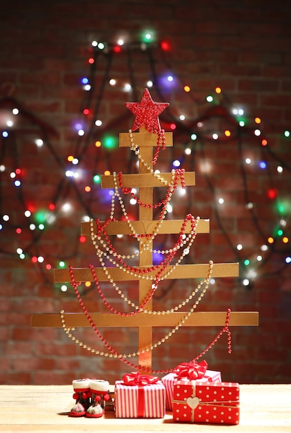 Un arbre de Noël fait main et des cadeaux sur la surface du mur