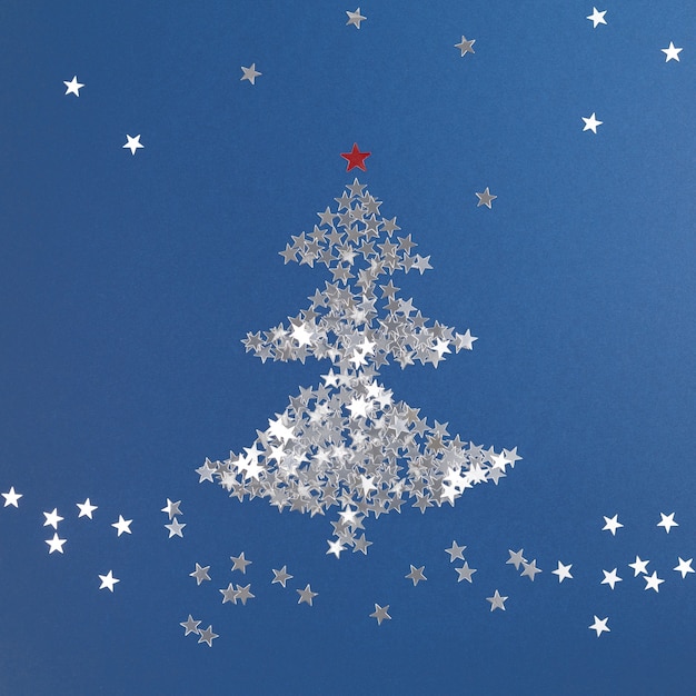 Arbre de Noël fait de paillettes d'argent en forme d'étoiles Composition de Noël Nouvel An Blue backgrou
