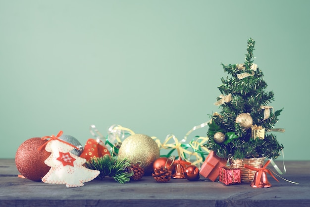 L'arbre de Noël festif se dresse sur des planches sombres.