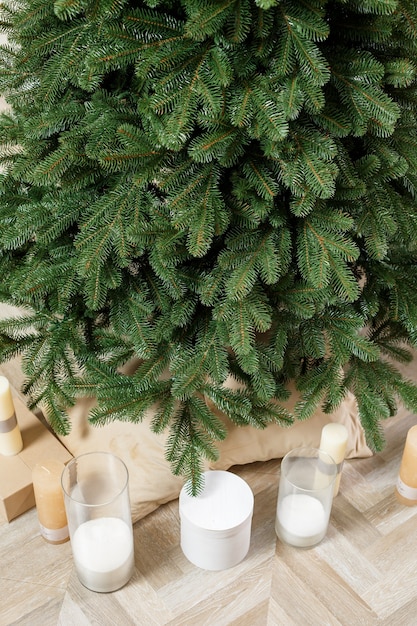 Photo arbre de noël en gros plan sans jouets. bon esprit du nouvel an. branches vertes d'un arbre de noël avec des cadeaux et des bougies