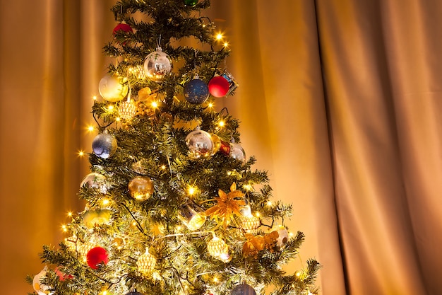 Arbre de Noël avec guirlandes et décoration dans la maison. Arbre vert décoratif et festif