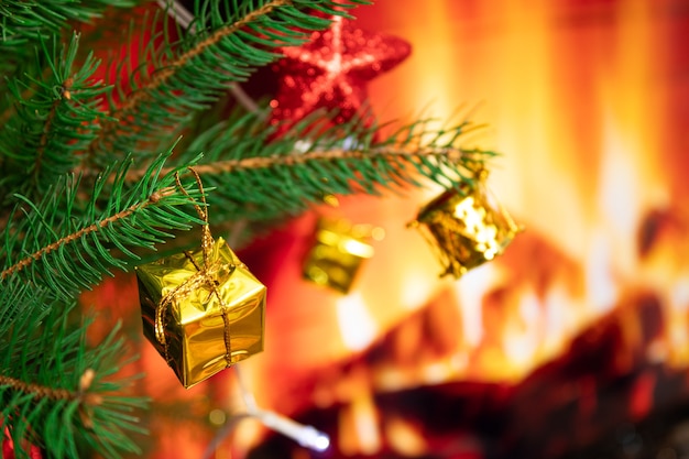 Arbre de Noël avec des jouets sur le fond d'une cheminée avec feu