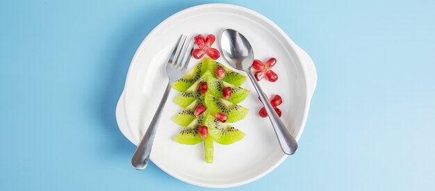 Arbre de Noël de kiwi et de grenade avec fourchette et couteau