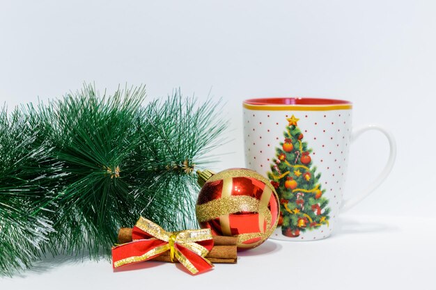 Arbre de Noël avec mug, cannelle et sphère rouge isolé sur fond blanc