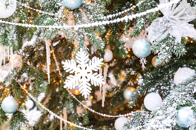 Arbre de Noël en plein air avec des flocons de neige blancs et décoration