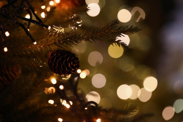 L'arbre de Noël avec une pomme de pin est décoré d'une guirlande