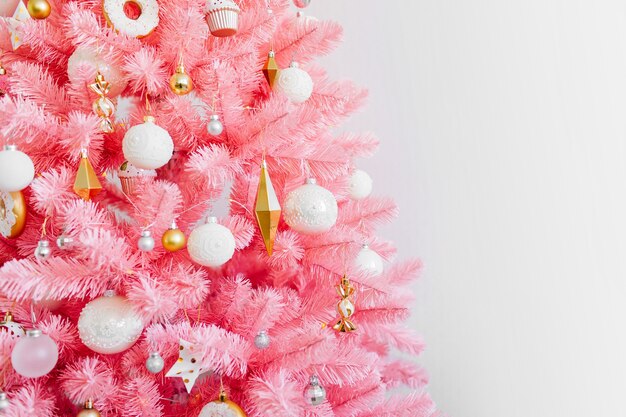 Arbre de Noël rose et décorations de Noël de couleur blanche et or. Fond de Noël. Bonne année et concept de Noël de Noël.
