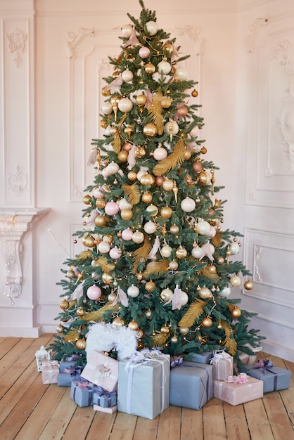 Arbre de Noël rose et or avec des cadeaux. Cadeaux de Noël sous l'arbre. Modèle de carte de nouvel an. Arbre de Noël avec des jouets. modèle de carte de voeux. Décoration d'arbre de Noël classique