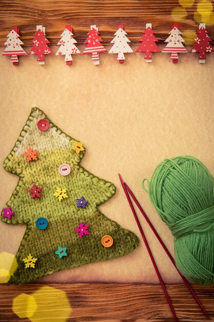 Arbre de Noël tricoté avec des boutons sur fond blanc de papier. Concept de vacances de Noël