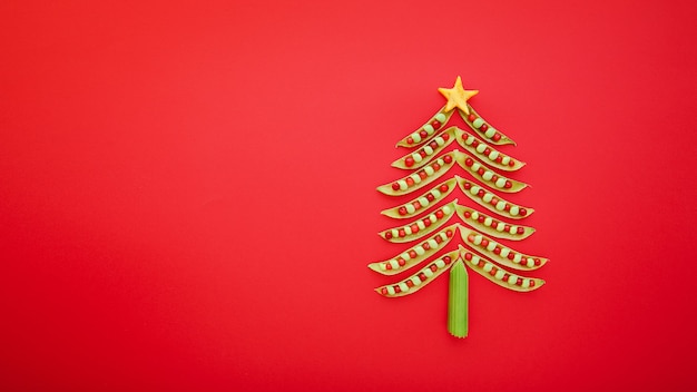 Arbre de Noël végétalien fait de pois verts sur fond rouge