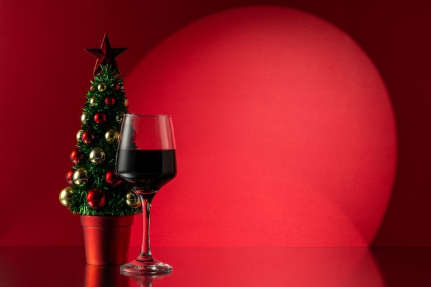 Arbre de Noël avec un verre de vin rouge Nouvel An ou fond de Noël