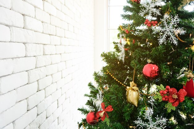 Arbre de Noël en vert avec un décor rouge dans la chambre.