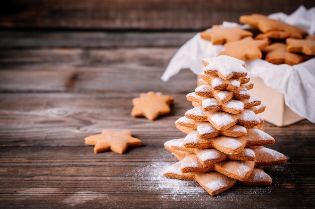 Arbre de pain d'épice de Noël au four fait maison avec du sucre glace sur fond de bois