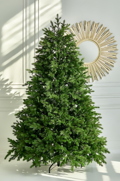 Photo arbre vert de noël artificiel sans décorations sur un support métallique isolé sur fond blanc