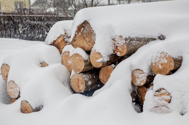 Arbres abattus sous la neige. Matières premières pour l'industrie du bois. Stockage de bois en plein air. Entreprise de bois. Charpente. Bois rond. Bois rond