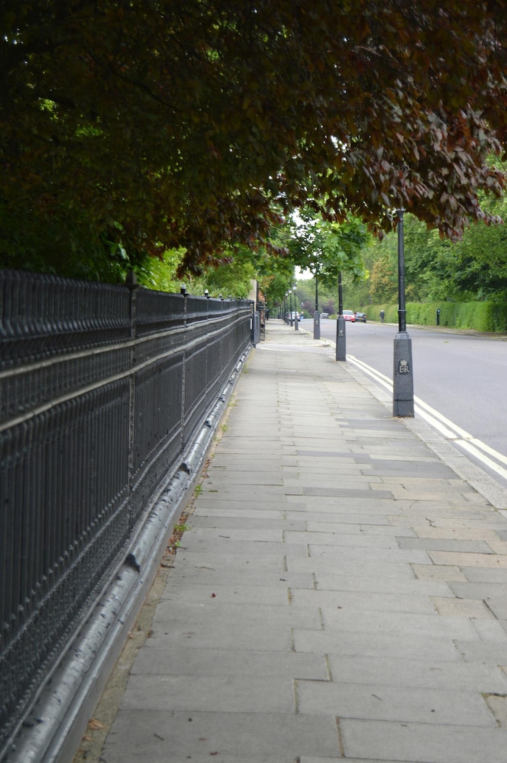 Photo des arbres et une clôture sur le trottoir