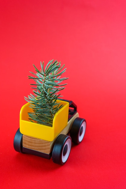 Arbres de Noël à l'arrière d'une petite voiture sur fond rouge du nouvel an.