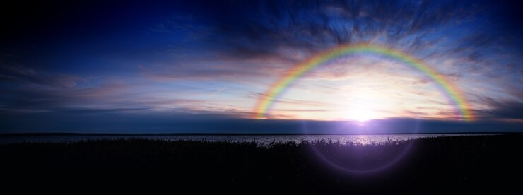 Arc-en-ciel dramatique au fond de paysage de rivière de coucher du soleil