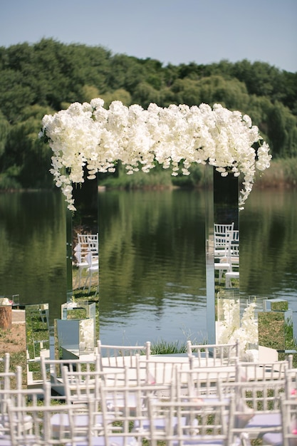 Arc de mariage en miroir blanc décoré de fleurs blanches