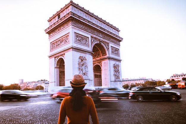 Arc de Triomphe et voyageur dans la rue de Paris au crépuscule nocturne