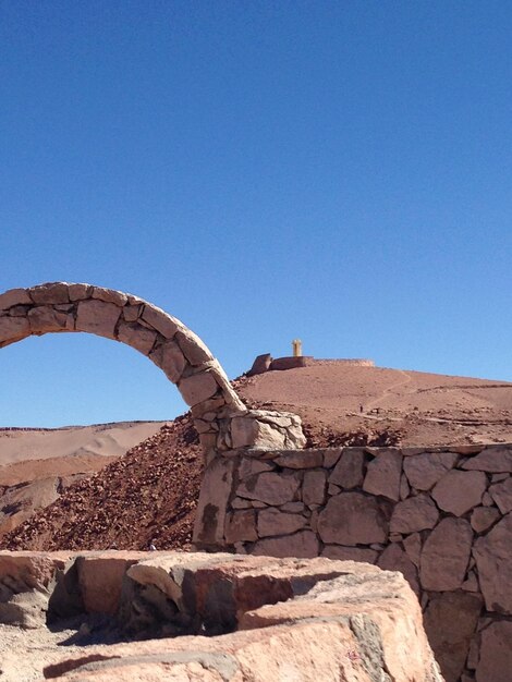 Photo arch par le mur dans le désert contre le ciel bleu