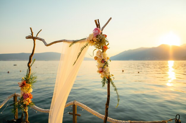 Arche en bois pour la cérémonie de mariage au coucher du soleil