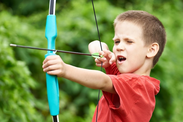 Archer de petit garçon avec arc et flèche