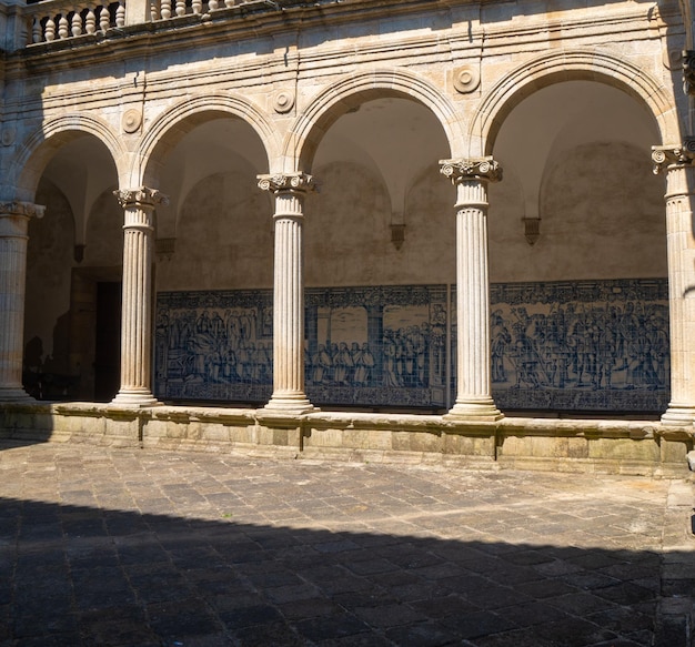 Arches ornées médiévales et panneaux de tuiles bleues qui recouvrent les murs du cloître de la cathédrale avec l'ombre du toit au sol Cathédrale de Santa Maria Viseu Portugal