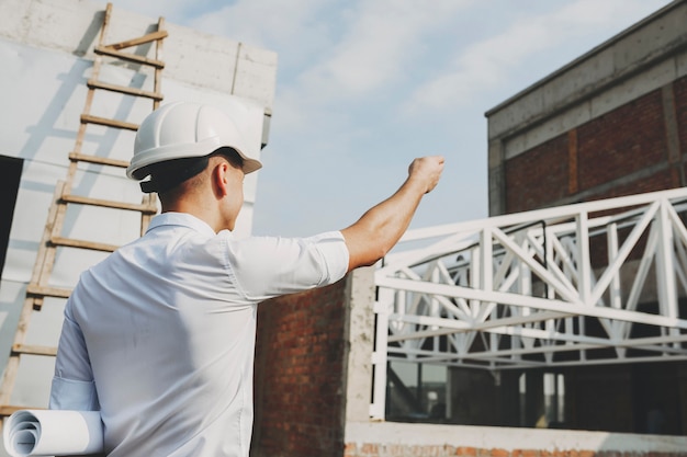 Architecte adulte masculin montrant par où commencer le travail le matin sur le bâtiment en construction.