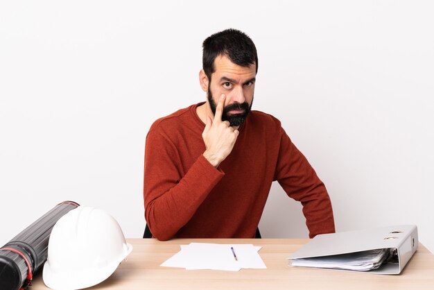 Architecte caucasien homme avec barbe dans un tableau montrant quelque chose