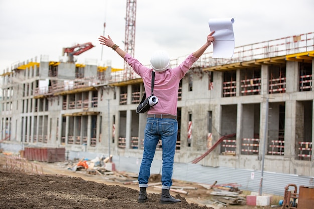 Un architecte sur un chantier de construction célèbre le succès du projet de construction