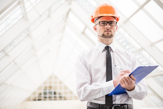 Architecte confiant avec casque au bureau.