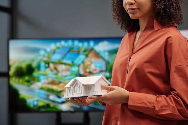 Architecte féminine tenant un modèle de maison