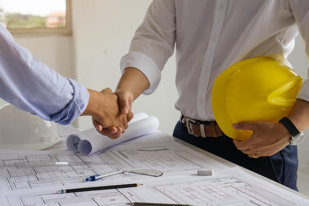 Un architecte et un ingénieur se serrent la main après avoir conclu un accord au bureau.
