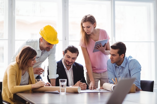 Architecte d'intérieur avec des collègues discutant du plan