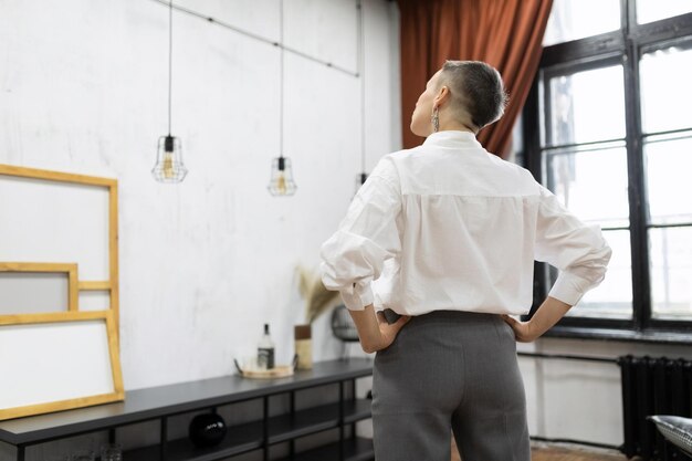 Architecte d'intérieur réfléchissant au concept de rénovation en regardant un mur vide dans un appartement